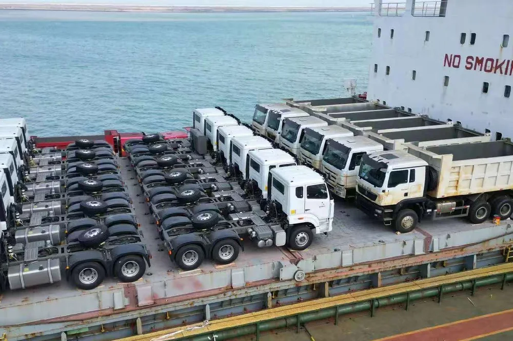 Rows of truck cabs and chassis secured on a vessel deck